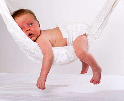 Müdes Baby in Hängematte – Sodbrennen beim Baby ist häufig und vergeht meist von selbst